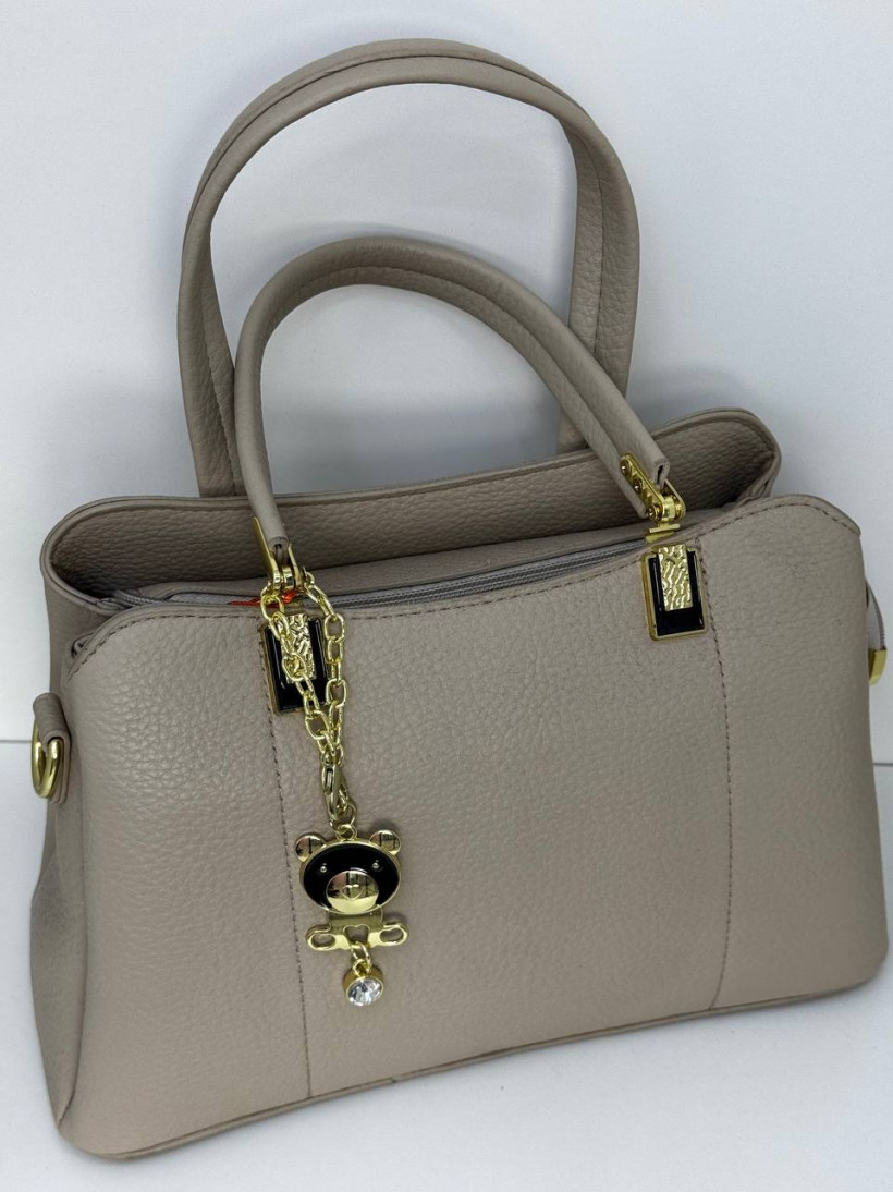 torebka bezowa prostokatna z cienkim paskiem i uszami z zamkiem ala klodka z zloto-czarna przywieszka misia z diamencikiem