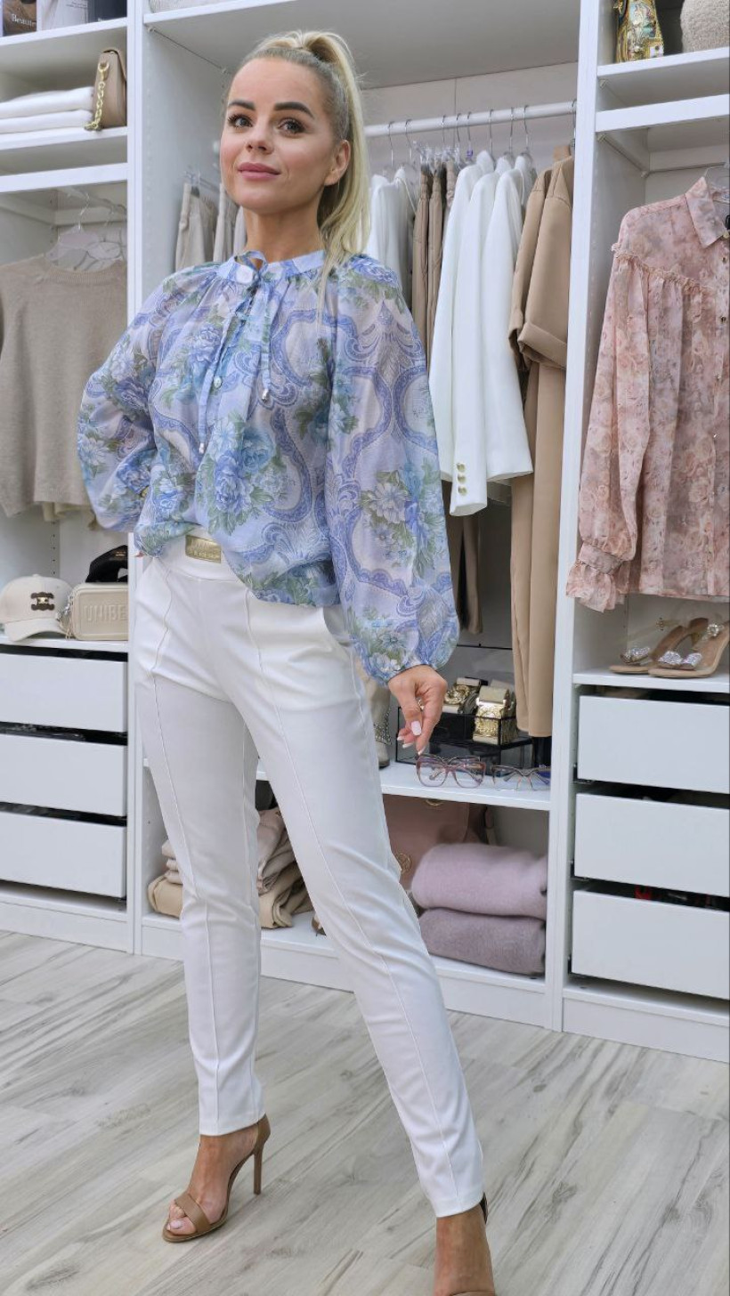 Koszula niebieska w kwiaty, na stójce, wiązana przy szyi.