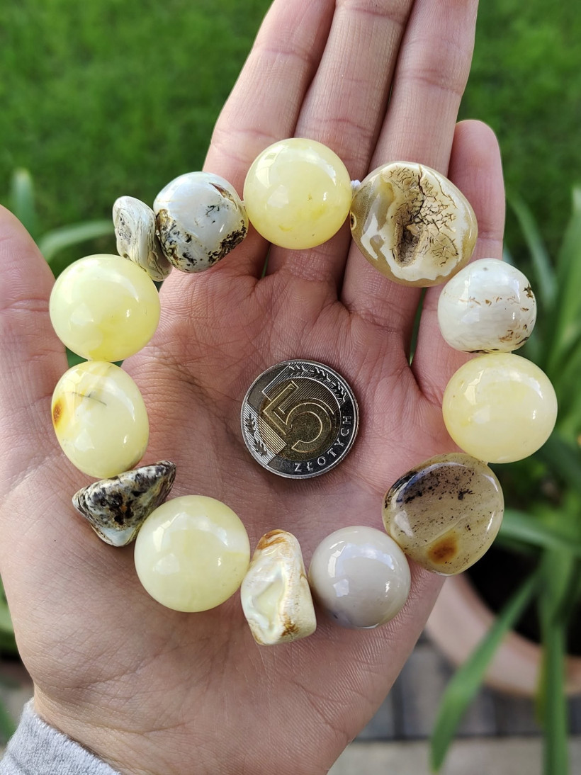 Bransoletka z naturalnego, mlecznego bursztynu bałtyckiego w odcieniach żółci, bieli i kremu – ręcznie wykonany, przyciągający wzrok dodatek, idealny na prezent lub do codziennego noszenia.